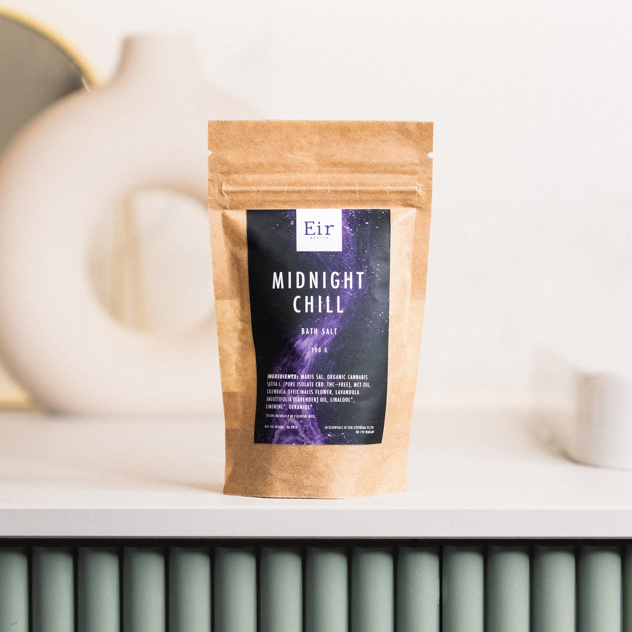Packaging of Eir's "Midnight Chill" bath salt, a brown paper pouch with a window and a deep purple label featuring cosmic-themed graphics.